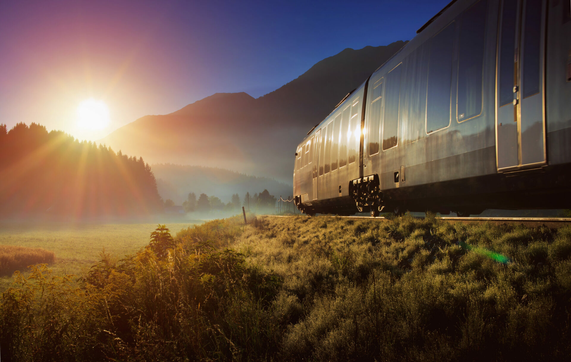 Railway and train in the Alpes at sunrise